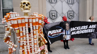'Pill Mann,' made by Frank Huntley of Worcester, Mass., from his opioid prescription pill bottles, is displayed during a protest outside the Department of Justice, Washington, D.C., Dec. 3, 2021.