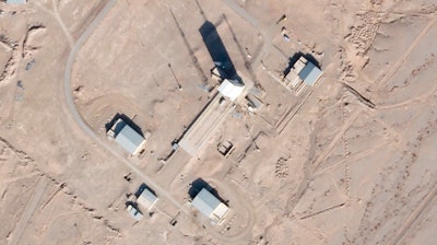 Satellite photo showing a support vehicle stands and large white gantry that typically houses a rocket at the Imam Khomeini Spaceport, Semnan province, Iran, Dec. 11, 2021.