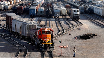 A BNSF rail terminal worker monitors the departure of a freight train in Galesburg, Ill., June 15, 2021.