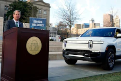 Georgia Gov. Brian Kemp is flanked by a Rivian electric truck announces that the electric truck maker plans to build a $5 billion battery and assembly plant east of Atlanta projected to employ 7,500 workers, Thursday, Dec. 16, 2021, in Atlanta.