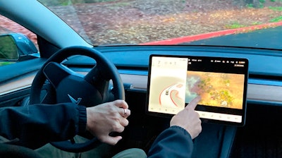Vince Patton, a new Tesla owner, demonstrates on Dec. 8, 2021, on a closed course in Portland, Ore., how he can play video games on the vehicle's console while driving. The U.S. has opened a formal investigation into a report that Tesla vehicles allow people to play video games on a center touch screen while they are driving.