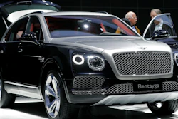 People stand at a Bentley Bentayga SUV car during the annual shareholders meeting of the Volkswagen AG in Hannover, Germany, Wednesday, May 10, 2017. Luxury automaker Bentley says it is pouring billions into upgrading manufacturing to accelerate its electric vehicle development plan, joining other auto brands shifting away from gasoline engines. U.K.-based Bentley Motors said Wednesday, Jan. 26, 2022 that it's investing 2.5 billion pounds ($3.4 billion) into sustainability efforts over the next decade.
