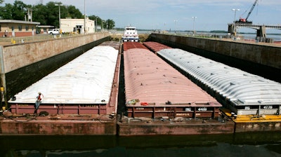 A towboat and its barges are shown in the channel at lock and dam 25 at Winfield, Mo., on Aug. 19, 2005. The U.S. Army Corps will spend $732 million to expand the congested lock and dam in Missouri. Federal officials said adding a second lock in Winfield will reduce travel time for barges and allow for two-way traffic. Funding for the lock's construction was part of a broader Biden administration announcement Wednesday, Jan. 19, 2022, to provide the Army Corps with $14 billon for infrastructure and environmental restoration projects.