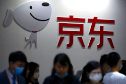 Visitors walk past a booth for Chinese online retailer JD.com at the China International Fair for Trade in Services (CIFTIS) in Beijing, Friday, Sept. 3, 2021. JD.com Inc., China’s biggest online retailer, and Canadian e-commerce service Shopify launched a venture Tuesday, Jan. 18, 2022, to give independent U.S. merchants access to JD.com’s 550 million customers.