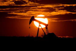 In this April 8, 2020 file photo, the sun sets behind an idle pump jack near Karnes City, USA. The 23-member OPEC+ group, led by member Saudi Arabia and non-member Russia, meets online to decide production levels from February. Analysts say the group is likely to add 400,000 barrels per day, sticking with the road map they have followed since August to add back that much oil each month.