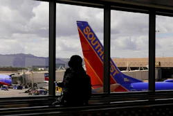 A passenger walks past a Southwest Airlines plane at Sky Harbor International Airport in Phoenix, March 26, 2021. AT&T and Verizon have agreed to delay the launch of a new slice of 5G service by two weeks after airlines and the nation's aviation regulator complained about potential interference with systems on board planes.
