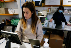 Deena Jalal, owner of plant-based ice cream chain FoMu, works behind the counter in her shop on Tremont Street, Friday, Jan 14, 2022, in Boston.