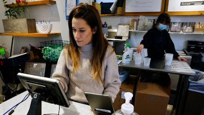 Deena Jalal, owner of plant-based ice cream chain FoMu, works behind the counter in her shop on Tremont Street, Friday, Jan 14, 2022, in Boston.