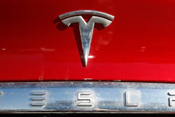 In this Feb. 2, 2020 file photo, the company logo sits on an unsold 2020 Model X at a Tesla dealership in Littleton, Colo. Tesla Inc. on Wednesday, Jan. 26, 2022 posted record fourth-quarter and full-year earnings as its deliveries soared despite a global shortage of computer chips that has slowed the entire auto industry. The Austin, Texas, company made $5.5 billion last year compared with the previous record year of $3.47 billion in net income posted in 2020. It was the electric vehicle and solar panel maker's third straight profitable year.