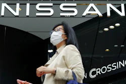 A woman walks by a Nissan showroom in Tokyo, May 11, 2021.