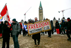 Don Stephens, 65, a retired graphic designer, holds a sign on Parliament Hill to support trucks lined up in protest of COVID-19 vaccine mandates and restrictions in Ottawa, Ontario, on Feb. 12, 2022.