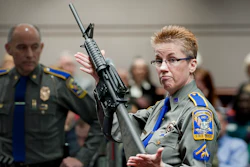 Firearms training unit Detective Barbara J. Mattson, of the Connecticut State Police, holds up a Bushmaster AR-15 rifle, the same make and model of gun used by Adam Lanza in the December 2012 Sandy Hook School shooting, during a hearing of a legislative subcommittee in Hartford, Conn., Jan. 28, 2013.