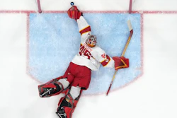 China goalkeeper Jieruimi Shimisi (Jeremy Smith) (45) reaches for a goal by United States' Brian O'Neill during a preliminary round men's hockey game at the 2022 Winter Olympics, Thursday, Feb. 10, 2022, in Beijing.