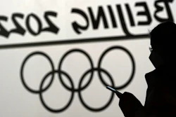 A woman looks at her phone inside the main media center for the 2022 Winter Olympics, Beijing, Jan. 18, 2022.