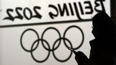 A woman looks at her phone inside the main media center for the 2022 Winter Olympics, Beijing, Jan. 18, 2022.