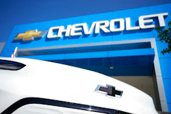 The company logo shines off the nose of an unsold Bolt electric vehicle on display in front of a Chevrolet dealership Sunday, Sept. 12, 2021, in Englewood, Colo. General Motors says it will start making Chevrolet Bolt electric vehicles again in early April after an eight-month pause due to a series of battery fire recalls. The automaker says Tuesday, Feb. 15, 2022, that battery supplier LG Energy Solution is now making enough to supply replacement modules for the recalls as well as to resume production.