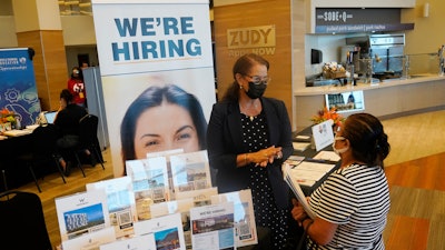 Marriott human resources recruiter Mariela Cuevas, left, talks to Lisbet Oliveros, during a job fair at Hard Rock Stadium, Friday, Sept. 3, 2021, in Miami Gardens, Fla.