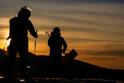 Workers arrive at the sunrise before the women's slopestyle finals at the 2022 Winter Olympics, Sunday, Feb. 6, 2022, in Zhangjiakou, China.