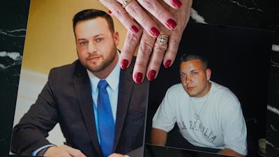 Cheryl Juaire holds photos of her sons Sean Merrill, left, and Corey Merrill, both of whom died from overdoses, New York, March 10, 2022.