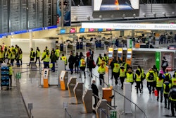 Security employees walk through an airport terminal during a one-day strike, Frankfurt, Germany, March 15, 2022.