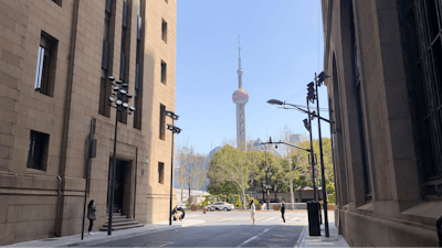 Residents walk along a quiet street with a view of the Oriental Pearl TV Tower in Shanghai, China, Tuesday, March 29, 2022. A two-phase lockdown of Shanghai's 26 million people is testing the limits of China's hard-line 'zero-COVID' strategy, which is shaking markets far beyond the country's borders.