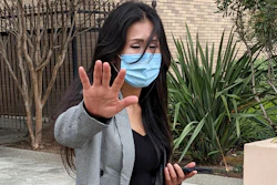 Julie Lee Choi waves off reporters outside Santa Clara Superior Court in San Jose, Calif., on Tuesday, March 29, 2022. Choi, accused of harassing Apple CEO Tim Cook with pleas for sex and other crude suggestions before showing up at his Silicon Valley home last autumn and suggesting she could become violent agreed to stay way from him for the next three years under an agreement approved Tuesday.