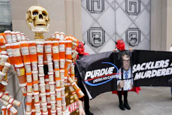 Pill Mann' made by Frank Huntley of Worcester, Mass., from his opioid prescription pill bottles, is displayed during a protest by advocates for opioid victims outside the Department of Justice, on Dec. 3, 2021, in Washington. Many families left heartbroken by opioid overdoses and addictions have been waiting for years to be able to tell another family – the Sacklers – about the damage their company, Purdue Pharma, did. Their chance arrives Thursday, March 10, 2022, in a federal court hearing to be conducted by video, during what could be the end of a long legal odyssey that will allow Purdue and the Sacklers to settle thousands of lawsuits.