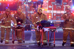Los Angeles Fire Department firefighters push gurneys at the scene of a structure fire that injured multiple firefighters, May 16, 2020. The owner of a downtown Los Angeles building where an explosion injured 12 firefighters has been allowed to enter a judicial diversion program that allows him to avoid jail time. A court commissioner on Wednesday, March 30, 2022, granted Steve Sungho Lee's request to enter the two-year program.