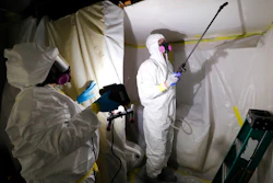 Asbestos Removal Technologies Inc., job superintendent Ryan Laitila, right, sprays amended water as job forman Megan Eberhart holds a light during asbestos abatement in Howell, Mich., Oct. 18, 2017. The Environmental Protection Agency on Tuesday, April 5, 2022, proposed a rule to finally ban asbestos, a carcinogen that is still used in some chlorine bleach, brake pads and other products and kills thousands of Americans every year.