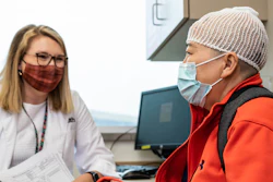 Patient Siyun Huang, right, wears an Optune device while talking with University of Cincinnati clinical research professional Alexis Brenner, left.