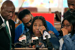Deon January, center, wipes tears from her eyes as she talks about her son DeAndre Morrow during a news conference in Edwardsville, Ill., May 3, 2022.