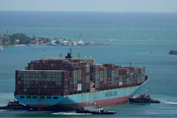 Three tugboats work together to rotate the Axel Maersk container ship as it arrives into port, on Oct. 21, 2021, in Miami.