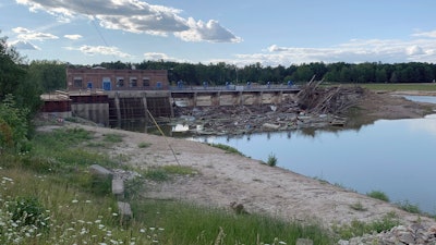 Debris rests at the spillway of the Sanford Dam in downtown Sanford, Mich., Thursday, July 30, 2020. The failure of two Michigan dams that forced evacuation of 10,000 people and destroyed 150 homes was “foreseeable and preventable,” resulting from errors and miscalculations over nearly a century, an expert panel said Wednesday, May 4, 2022.