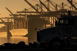 A truck arrives to pick up a shipping container near vessels moored at Maersk APM Terminals Pacific at the Port of Los Angeles, Nov. 30, 2021.