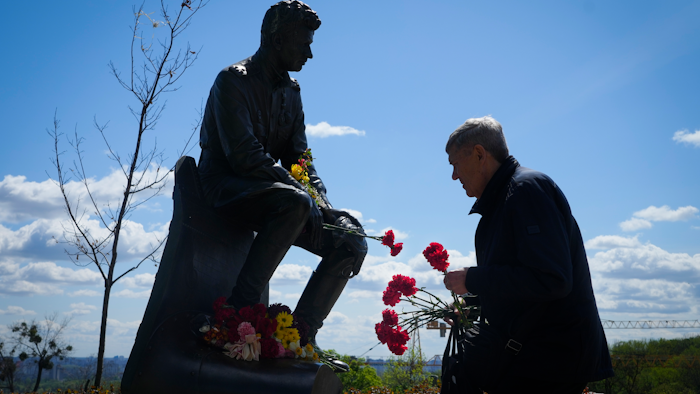 A man lays flowers at an Unknown Soldier Tomb to mark Victory Day in World War II, Kyiv, Ukraine, May 9, 2022.