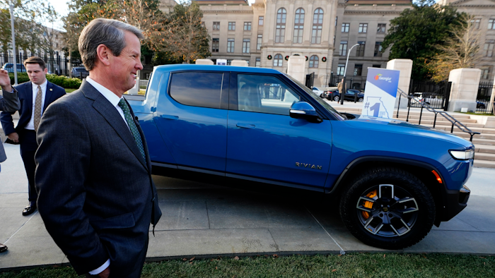 Gov. Brian Kemp stands next to a Rivian electric truck while announcing the company's plans to build a $5 billion plant east of Atlanta projected to employ 7,500 workers, Thursday, Dec. 16, 2021, in Atlanta. Georgia officials could announce a second massive electric vehicle plant to be built by Hyundai near Savannah in coming days.