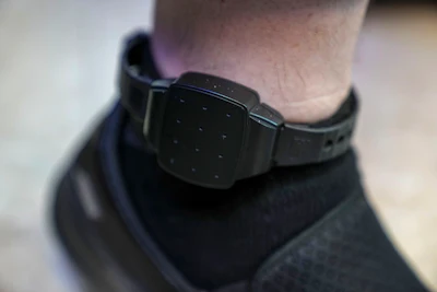 Harel Hershtik has his electronic monitoring device for convicted and released prisoners on his left leg as he works in his labs in Rehovot, central Israel, Wednesday, May 11, 2022. When he was 20 years old, Hershtik planned and executed a murder. Today, he is the brains behind an Israeli health-tech startup, poised to make millions of dollars with the backing of prominent public figures and deep-pocketed investors.
