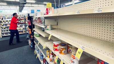 An employee walks near empty shelves where baby formula would normally be located at a CVS in New Orleans on Monday, May 16, 2022. President Joe Biden's administration has announced new steps to ease the national shortage of baby formula, including allowing more imports from overseas.