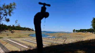 In this May 22, 2021, file photo, water drips from a faucet near boat docks sitting on dry land at the Browns Ravine Cove area of drought-stricken Folsom Lake in Folsom, Calif. California Gov. Gavin Newsom threatened Monday, May 23, 2022, to impose mandatory, statewide restrictions on water use if people don't start using less on their own as the drought drags on and the hotter summer months approach.
