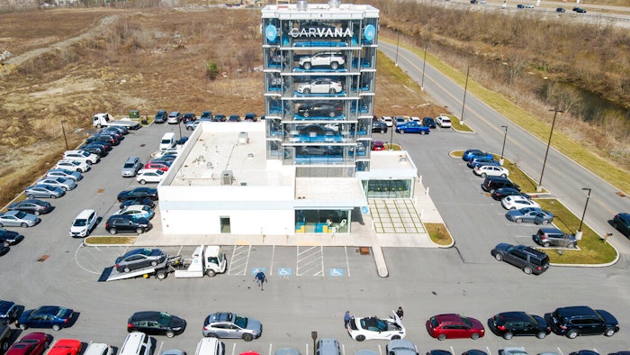 This aerial image taken with a drone, shows a Carvana car retail 'vending machine' and vehicle parking lot in South Fayette, Pa, on March 15, 2021. Online automotive retailer Carvana Co. says it's letting go about 2,500 workers, roughly 12% of its workforce, as it tries to bring staffing and expenses in line with sales. The Phoenix company said in a regulatory filing Tuesday, May 10, 2022, that its executive team is giving up salaries for the rest of the year to help fund severance pay for the workers.