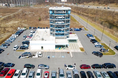 This aerial image taken with a drone, shows a Carvana car retail 'vending machine' and vehicle parking lot in South Fayette, Pa, on March 15, 2021. Online automotive retailer Carvana Co. says it's letting go about 2,500 workers, roughly 12% of its workforce, as it tries to bring staffing and expenses in line with sales. The Phoenix company said in a regulatory filing Tuesday, May 10, 2022, that its executive team is giving up salaries for the rest of the year to help fund severance pay for the workers.