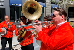 Dan Gabel, right, and fellow musicians perform in downtown Boston, Tuesday, May 10, 2022. Gabel has canceled Netflix and other streaming services and tried to cut back on driving as the costs of gas, food, and other items, such as the lubricants he uses for his instruments, has soared. In the photo, from left to right, are Eric Baldwin, banjo; Ed Goroza, sousaphone; Josiah Reibstein, trombone; and Gabel, trumpet.