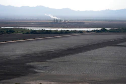 A dried up portion of the Salton Sea stretches out with a geothermal power plant in the distance in Niland, Calif., Thursday, July 15, 2021. Demand for electric vehicles has shifted investments into high gear to extract lithium from geothermal wastewater around the rapidly shrinking body of water. The ultralight metal is critical to rechargeable batteries.