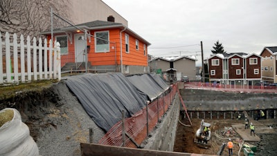 A single-family home on the edge of a multi-story, mixed-use construction site, Seattle, Dec. 27, 2017.