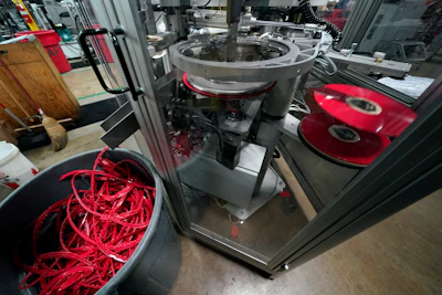 Excess vinyl falls into a bin after it has been shaved from the edge of a freshly pressed record at the United Record Pressing facility Thursday, June 23, 2022, in Nashville, Tenn. The excess vinyl will be reground and used to make more albums.