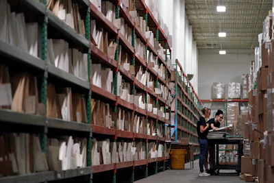 Sara Aulidge, left, and Abbey Peterson pull stampers, made of nickel and used to press vinyl record albums, from tall storage rows for upcoming orders at the United Record Pressing facility Thursday, June 23, 2022, in Nashville, Tenn.