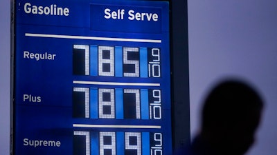 High gas prices are shown as a pedestrian waits to cross the street in Los Angeles, June 16, 2022. President Joe Biden on June 22 will call on Congress to suspend the federal gasoline and diesel taxes for three months. It's a move meant to ease financial pressures at the pump that also reveals the political toxicity of high gas prices in an election year.