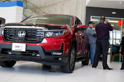 Customers confer with a salesperson as a 2022 Ridgeline pickup truck sits on the showroom floor of a Honda dealership, Friday, April 15, 2022, in Highlands Ranch, Colo.