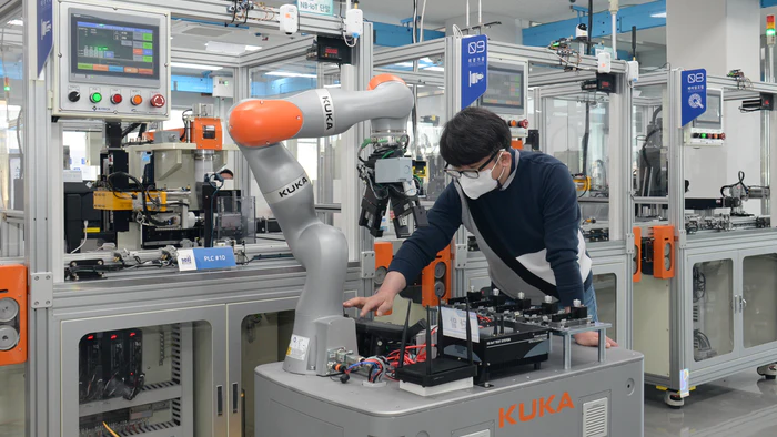 A researcher of the ETRI is controlling a mobile robot by using 5G technology in smart factory.