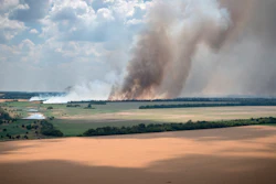 Smoke rises from the front lines with farm fields in the foreground, Dnipropetrovsk region, Ukraine, July 4, 2022.